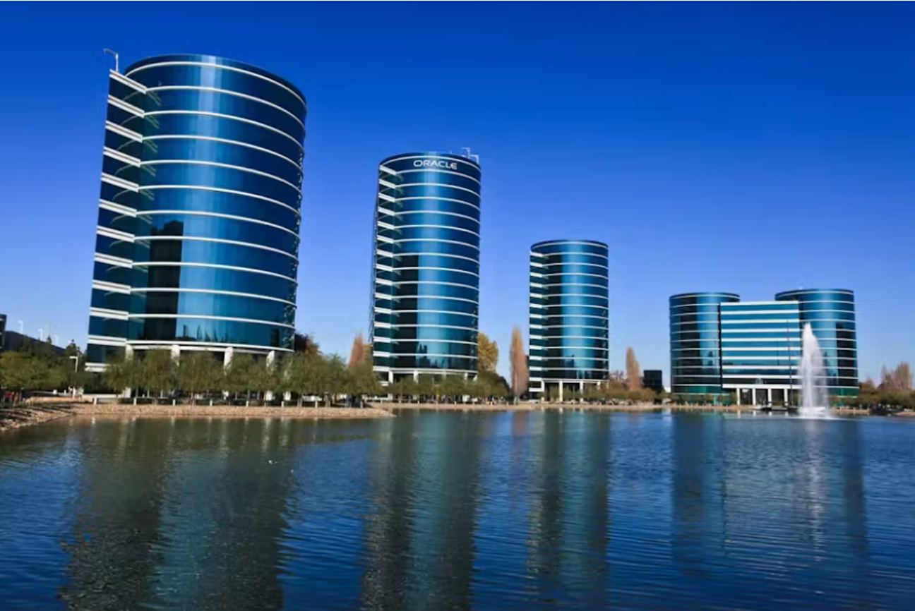 Oracle's corporate campus building, its signage lit at dusk.